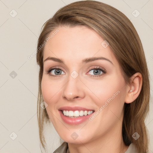 Joyful white young-adult female with long  brown hair and blue eyes