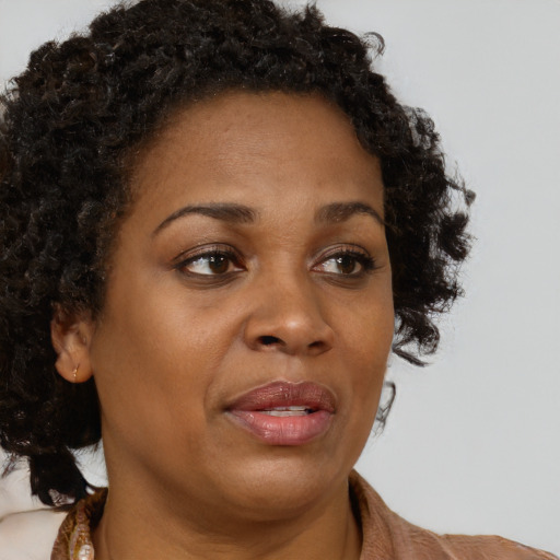 Joyful black adult female with medium  brown hair and brown eyes