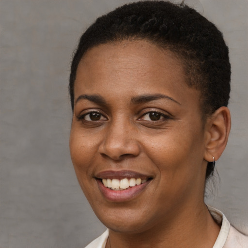 Joyful black young-adult female with short  brown hair and brown eyes