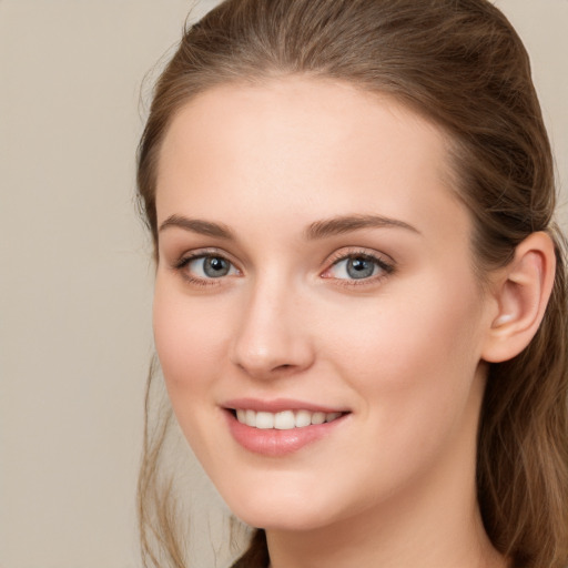 Joyful white young-adult female with long  brown hair and grey eyes