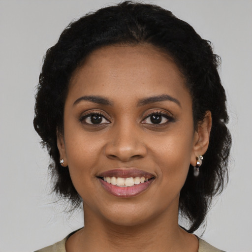 Joyful black young-adult female with long  black hair and brown eyes