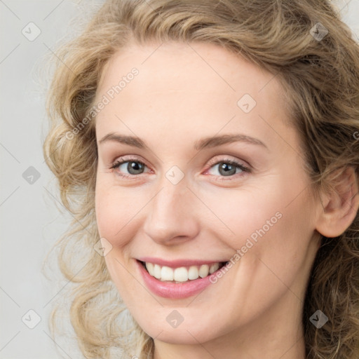 Joyful white young-adult female with medium  brown hair and blue eyes