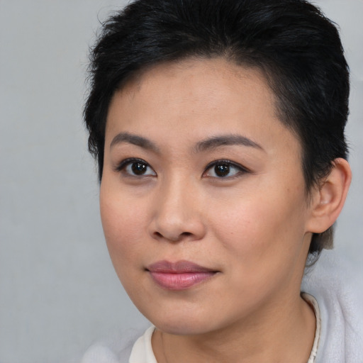 Joyful asian young-adult female with short  brown hair and brown eyes