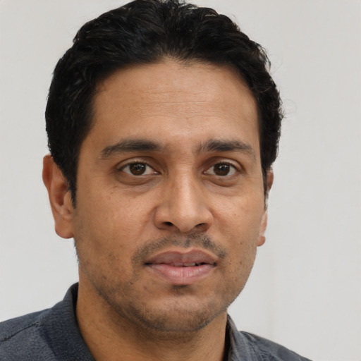 Joyful asian adult male with short  black hair and brown eyes