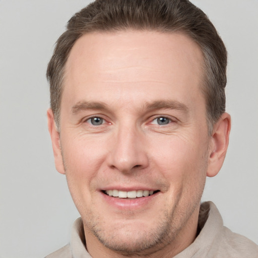 Joyful white adult male with short  brown hair and grey eyes