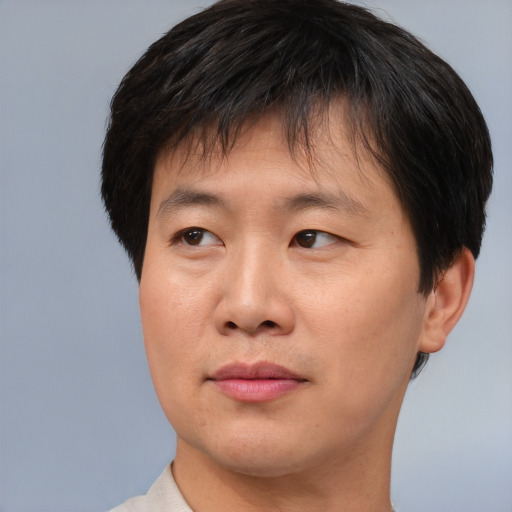 Joyful asian young-adult male with short  brown hair and brown eyes