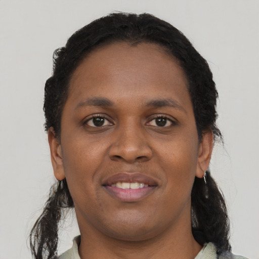 Joyful black young-adult female with short  black hair and brown eyes