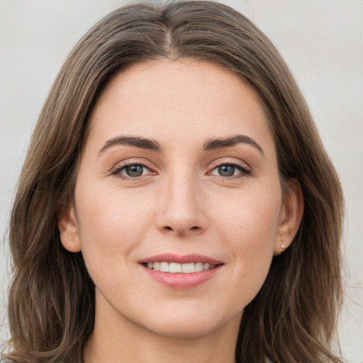 Joyful white young-adult female with long  brown hair and grey eyes