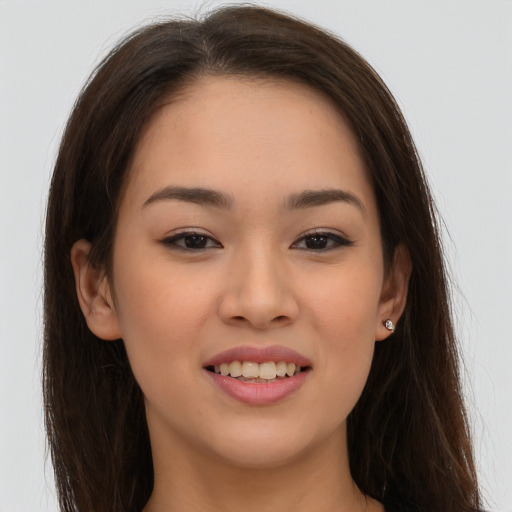 Joyful asian young-adult female with long  brown hair and brown eyes