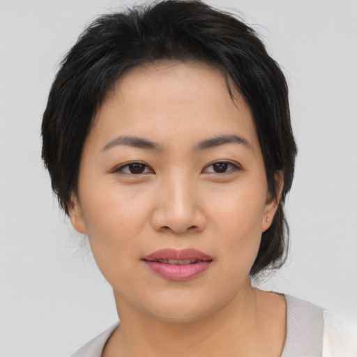 Joyful asian young-adult female with short  black hair and brown eyes