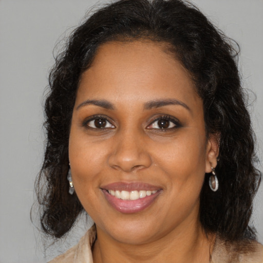 Joyful black young-adult female with long  brown hair and brown eyes