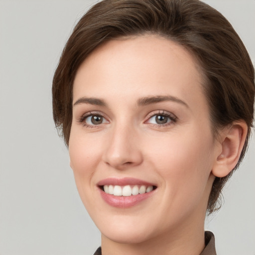 Joyful white young-adult female with medium  brown hair and grey eyes