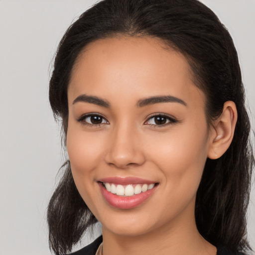 Joyful latino young-adult female with long  brown hair and brown eyes