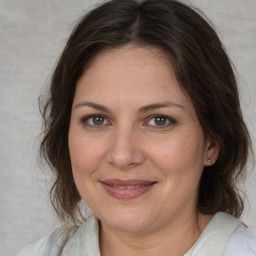 Joyful white adult female with medium  brown hair and brown eyes