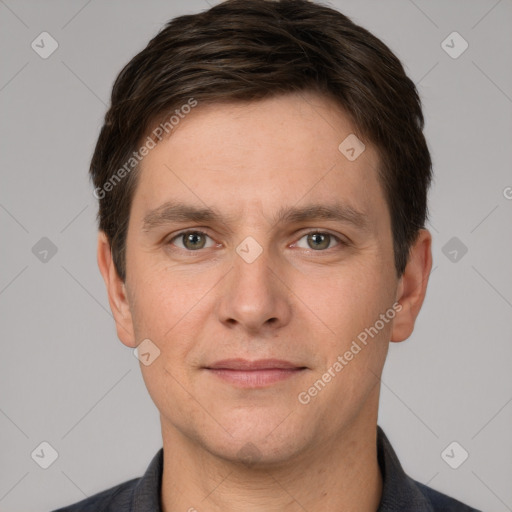 Joyful white young-adult male with short  brown hair and grey eyes