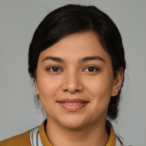 Joyful latino young-adult female with short  black hair and brown eyes