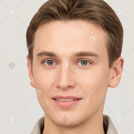 Joyful white young-adult male with short  brown hair and grey eyes