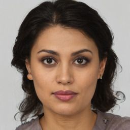 Joyful latino young-adult female with medium  brown hair and brown eyes