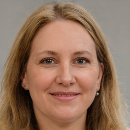 Joyful white adult female with long  brown hair and brown eyes