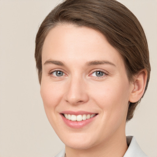 Joyful white young-adult female with short  brown hair and grey eyes