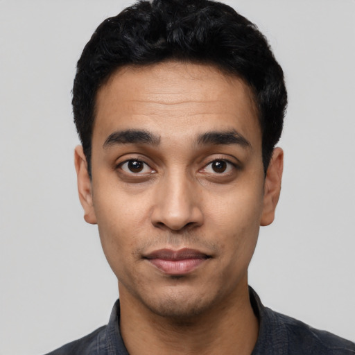 Joyful latino young-adult male with short  black hair and brown eyes