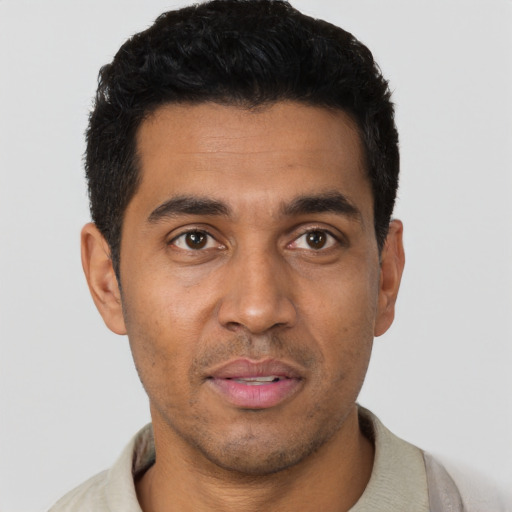 Joyful latino young-adult male with short  black hair and brown eyes