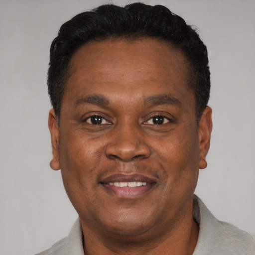 Joyful black adult male with short  brown hair and brown eyes