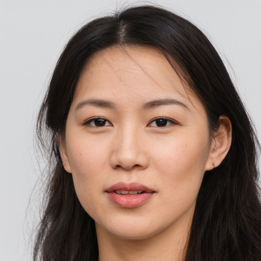 Joyful asian young-adult female with long  brown hair and brown eyes