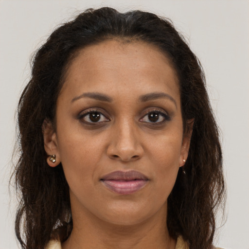 Joyful black adult female with long  brown hair and brown eyes