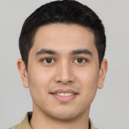 Joyful latino young-adult male with short  brown hair and brown eyes