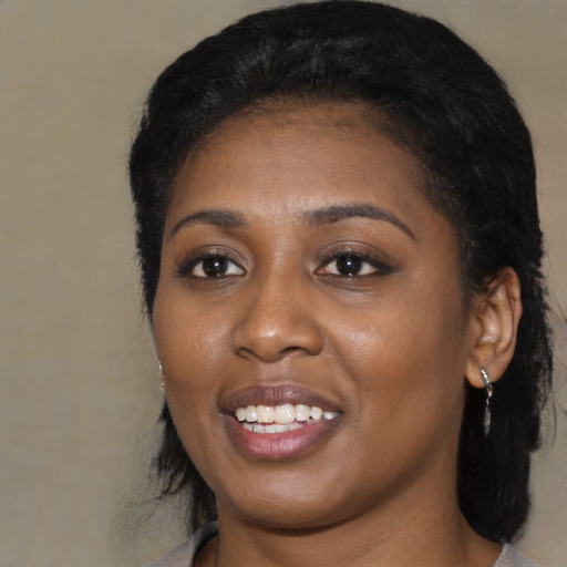 Joyful black young-adult female with medium  black hair and brown eyes