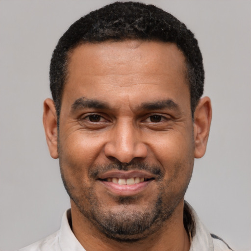 Joyful latino adult male with short  black hair and brown eyes