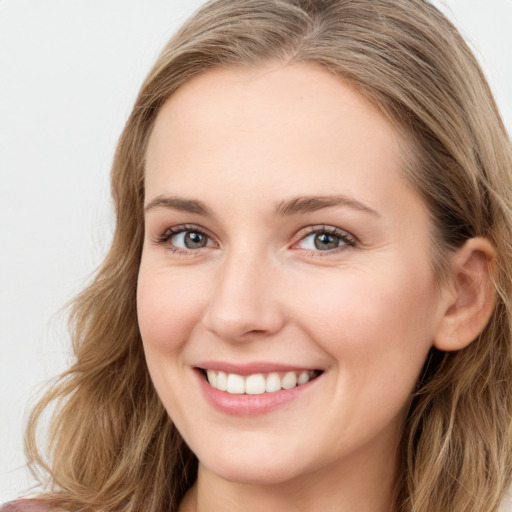 Joyful white young-adult female with long  brown hair and blue eyes