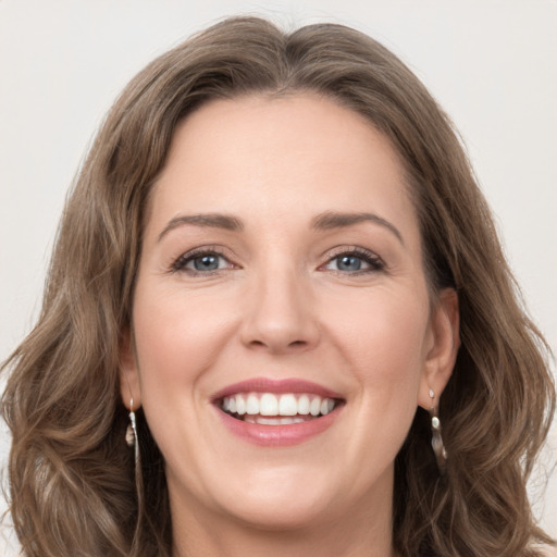 Joyful white young-adult female with long  brown hair and green eyes