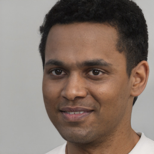 Joyful black young-adult male with short  black hair and brown eyes