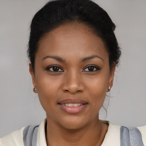 Joyful black young-adult female with short  black hair and brown eyes