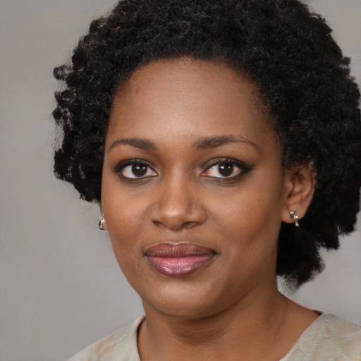 Joyful black young-adult female with short  black hair and brown eyes