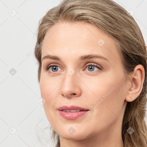 Joyful white young-adult female with long  brown hair and blue eyes