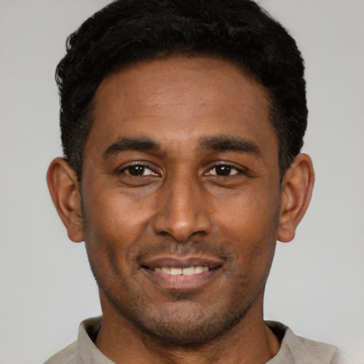 Joyful latino young-adult male with short  black hair and brown eyes