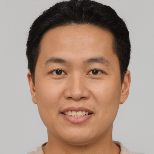 Joyful asian young-adult male with short  brown hair and brown eyes