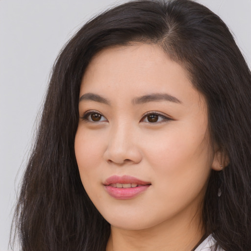Joyful asian young-adult female with long  brown hair and brown eyes