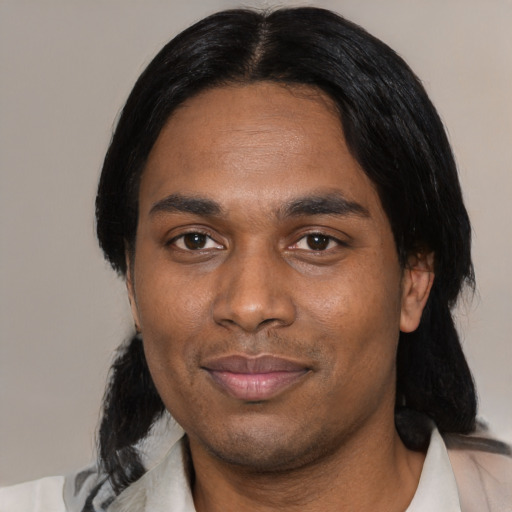 Joyful black adult male with medium  black hair and brown eyes
