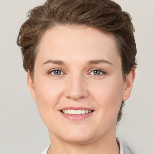 Joyful white young-adult female with short  brown hair and grey eyes