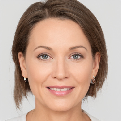 Joyful white young-adult female with medium  brown hair and grey eyes