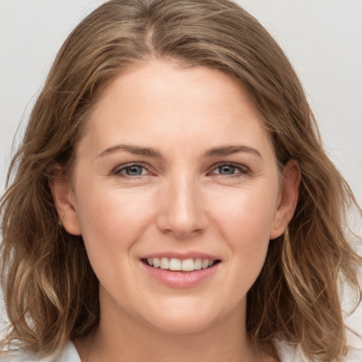 Joyful white young-adult female with long  brown hair and grey eyes