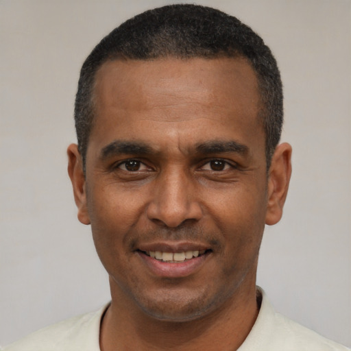 Joyful latino adult male with short  black hair and brown eyes