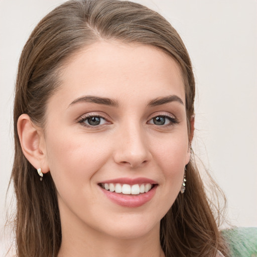 Joyful white young-adult female with long  brown hair and blue eyes