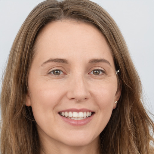 Joyful white young-adult female with long  brown hair and grey eyes