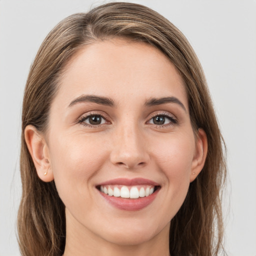 Joyful white young-adult female with long  brown hair and grey eyes