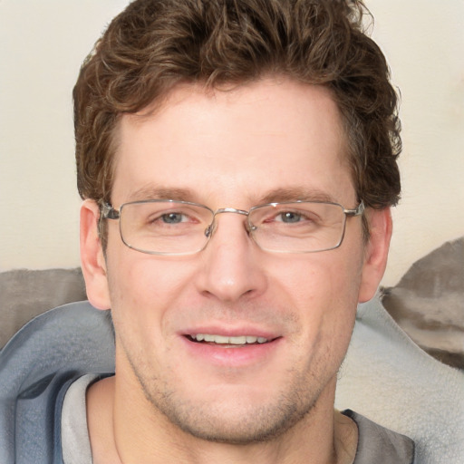 Joyful white adult male with short  brown hair and blue eyes